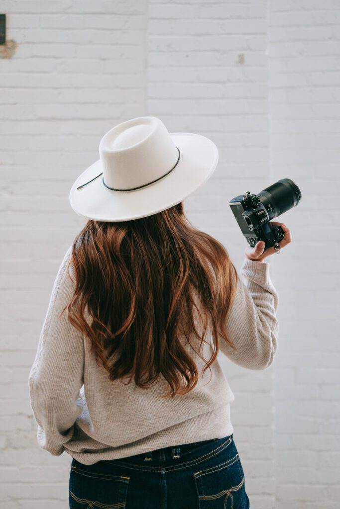 A backside view of a woman holding a camera for her Denver Branding photos by a Denver Branding Photographer and brand strategist.
