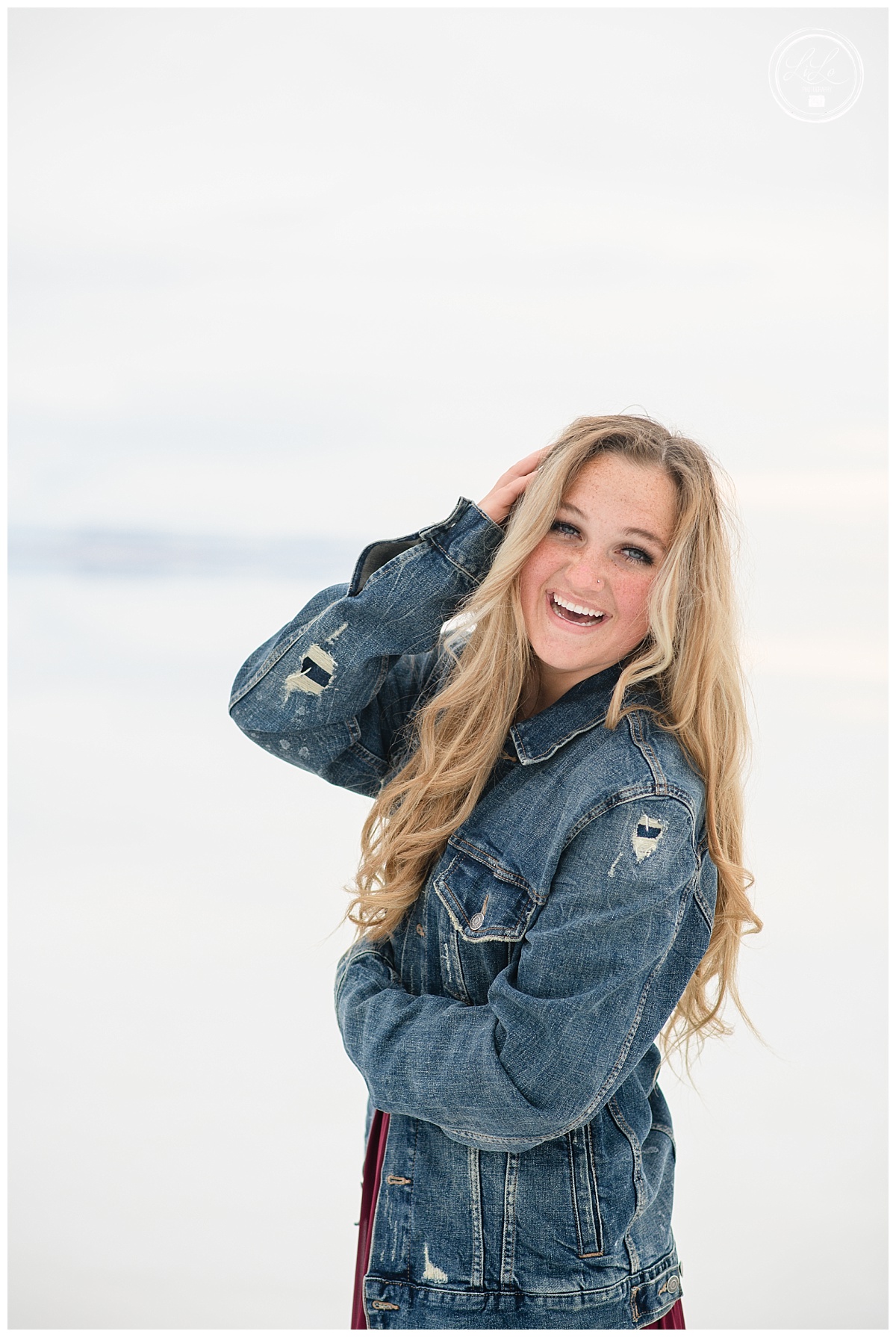 senior picture with girl in a denim jack walking on the salt flats in Utah photographed by Denver senior photographer