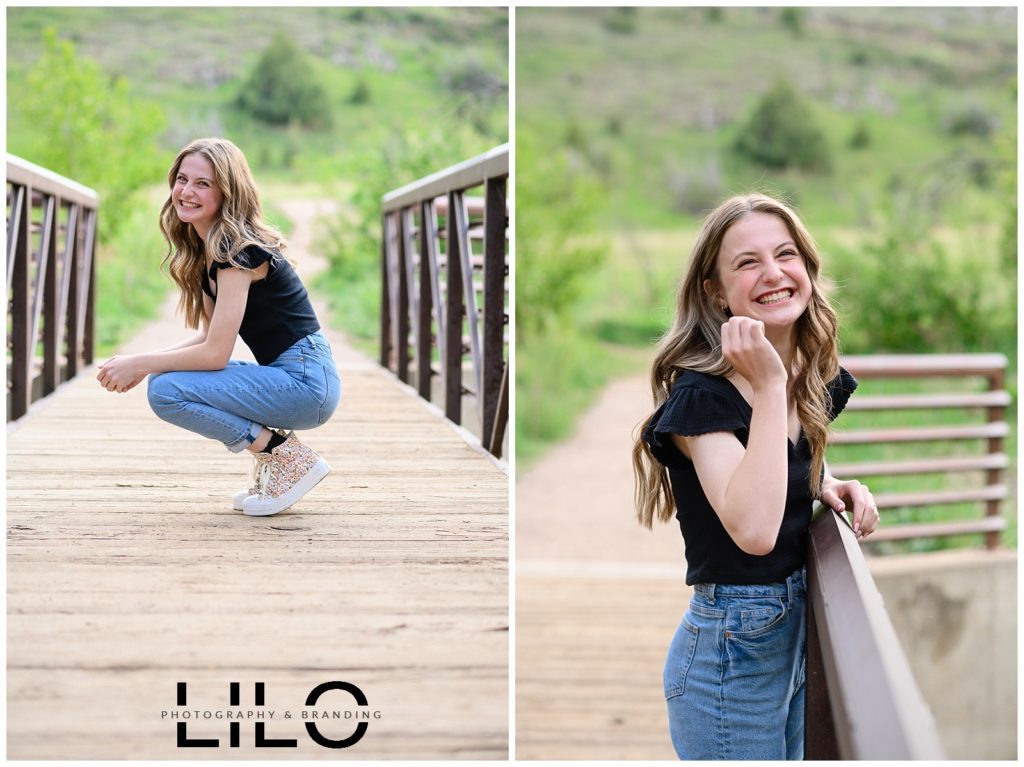 Girl in black shirt and mom jeans smiles on a bridge at Lair O the Bear Park in Morrison colorado for her Denver senior pictures.