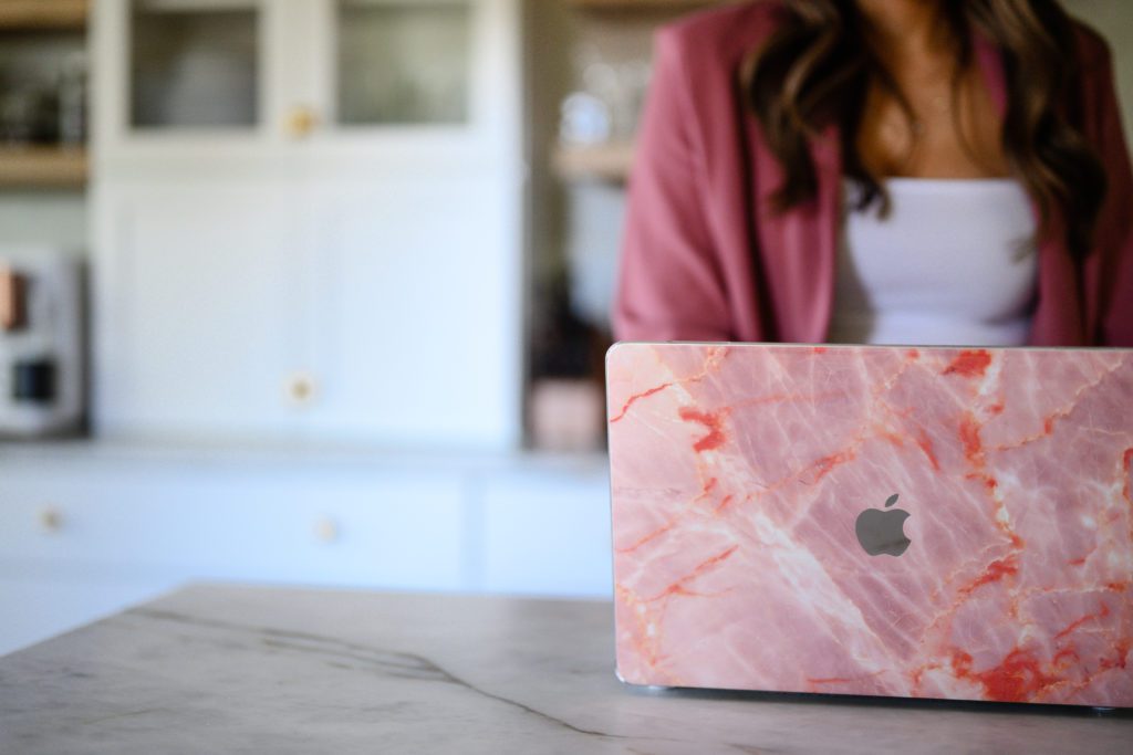 denver commercial photographers take a picture of a closeup of a mac laptop with a pink marbled cover.
