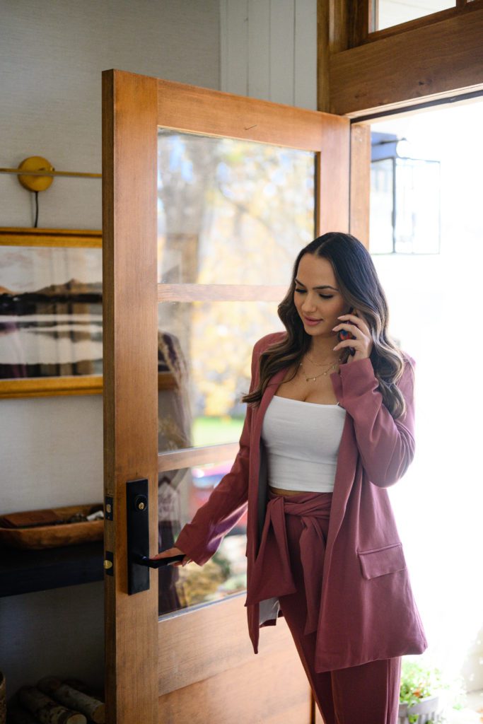 Lifestyle branding photos of a woman walking in from the front door hold her cell phone by denver commercial photographers