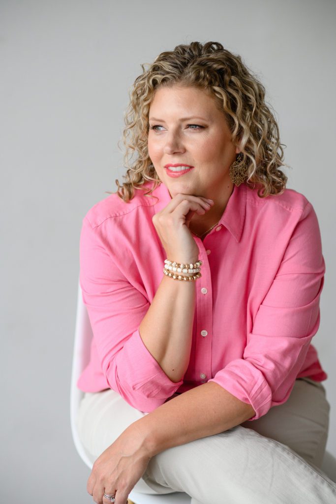 Denver Commercial Photographers captures woman with blonde curly hair wearing a pink button down top for her personal branding photos.