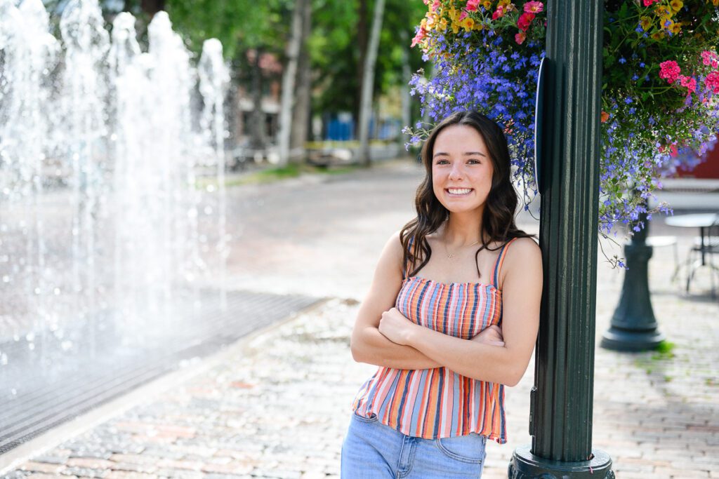 Senior girl in downtown Aspen with flowers and water