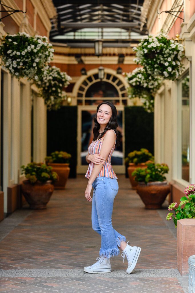 Senior girl in a alley with flowers in Downtown Aspen Colorado for her colorado mountain senior pictures