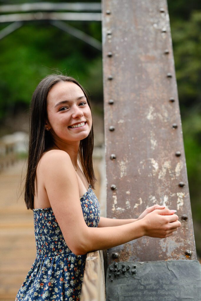 Denver senior photographer takes a cute photo of a dark haired girl leaning on a bridge in aspen colorado for her Denver senior pictures