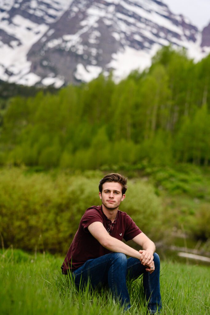 Maroon Bells senior pictures of a guy sitting on a rock captured by Denver senior photographer