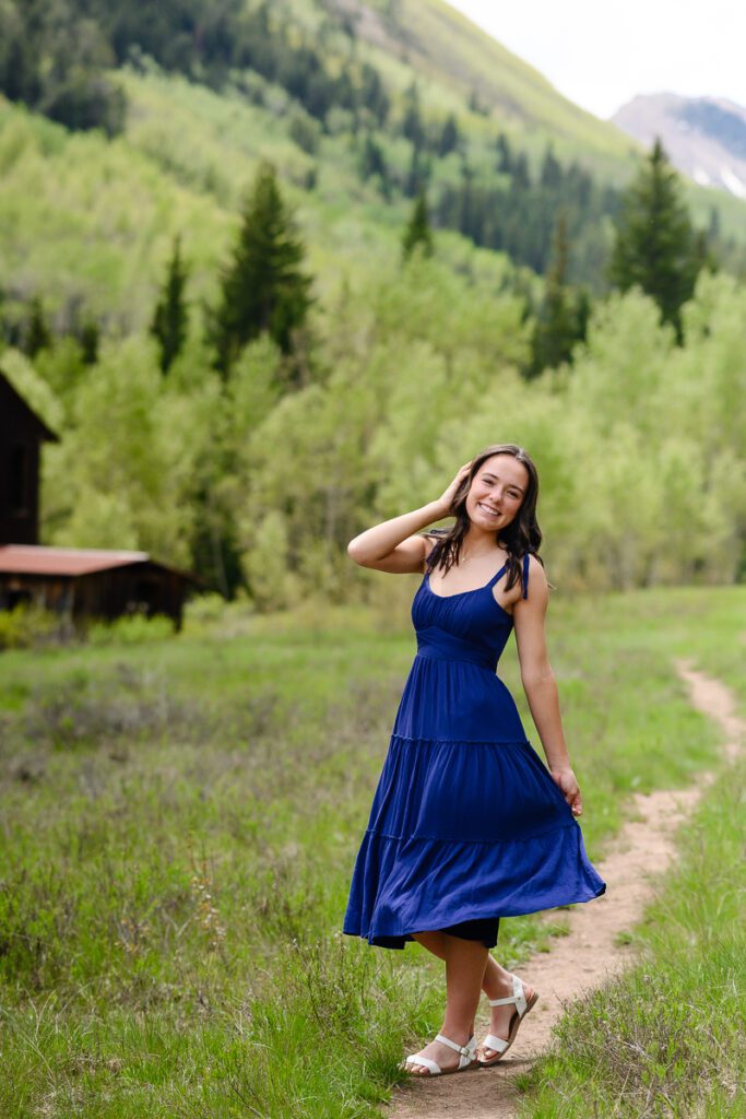 A Senior girl with mountains in the background of her Aspen Senior pictures as captured by a denver senior photographer