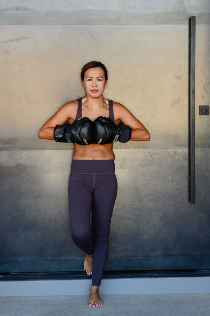 Denver commercial photographer captures atheletic woman in workout gear with boxing gloves.