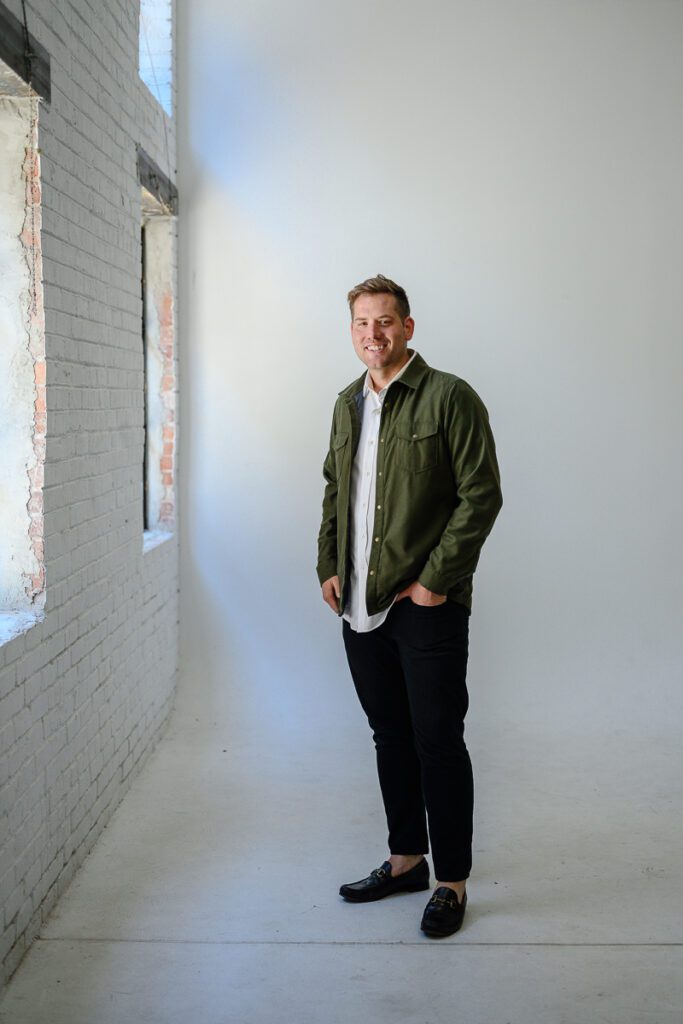 Denver Branding Photographer takes a picture of a man in a green jacket standing in a studio.
