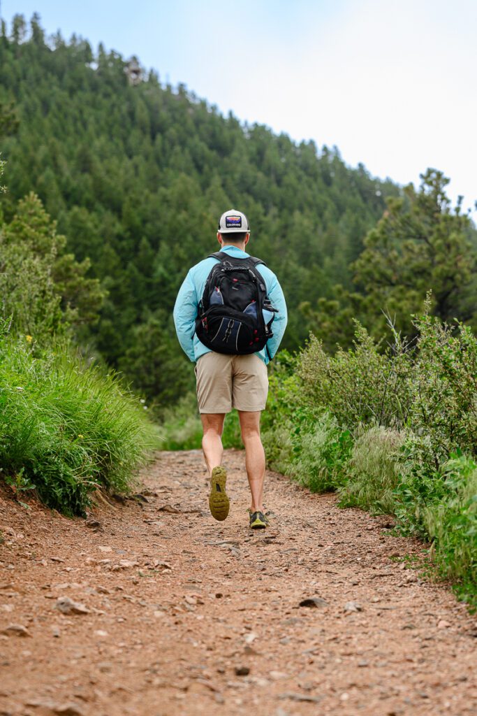 A man walking on a mountain trail for his Denver Branding photos.