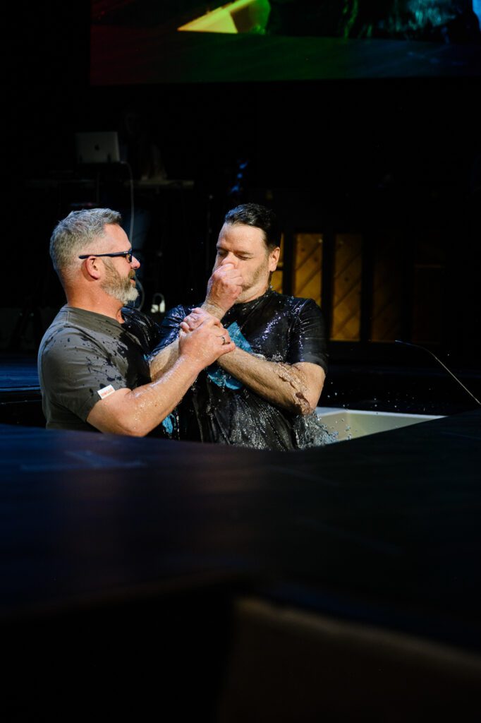 A man being baptized at a church as captured by a Denver Branding photographer and Denver Church branding photographer.