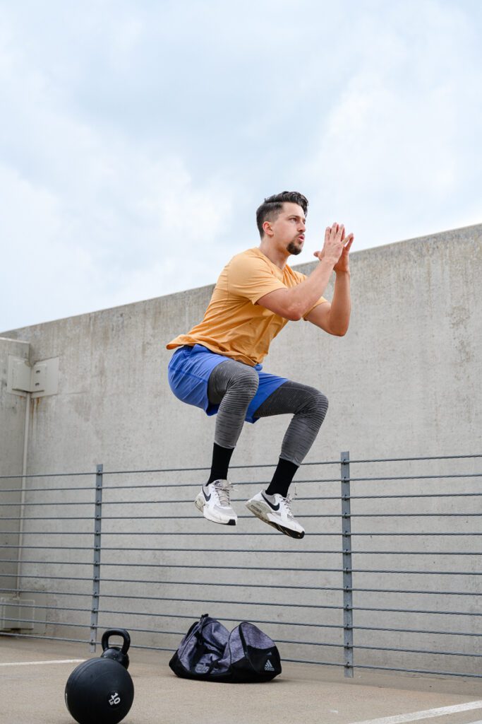 A man with a fitness business is jumping while taking photos for his Denver Branding photos.