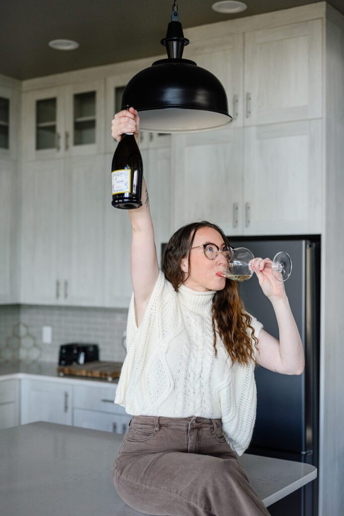 A woman celebrating by holding up a bottle of champagne for her Denver Branding photos captured by Denver Commercial photographers.