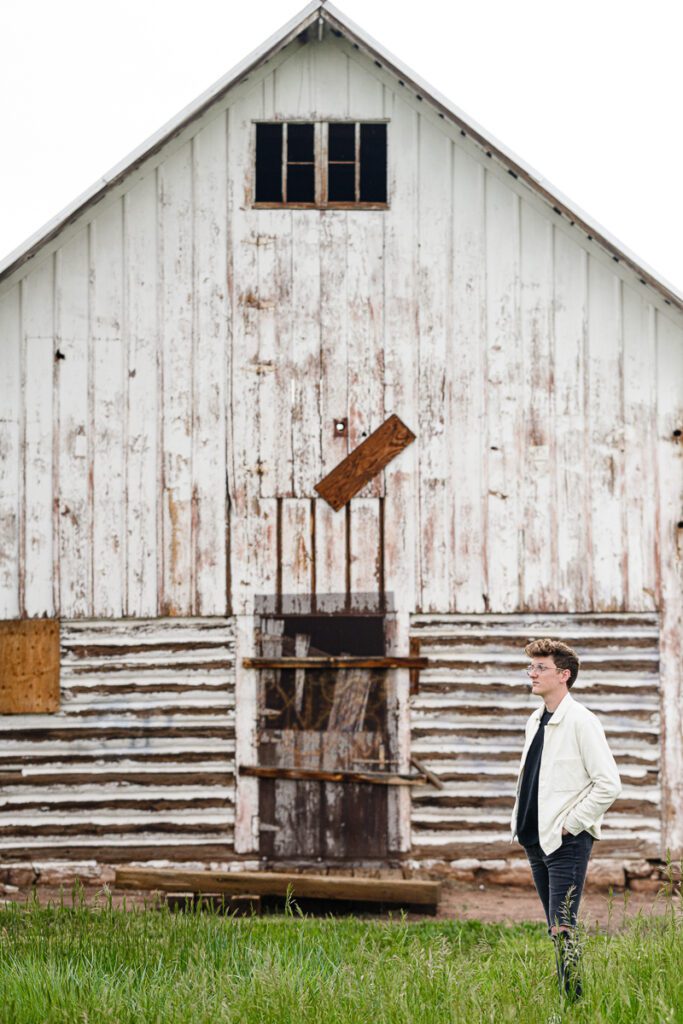 An album cover for a musician standing in front of a barn captured by a Denver branding photographer for Branding photos for musicians.