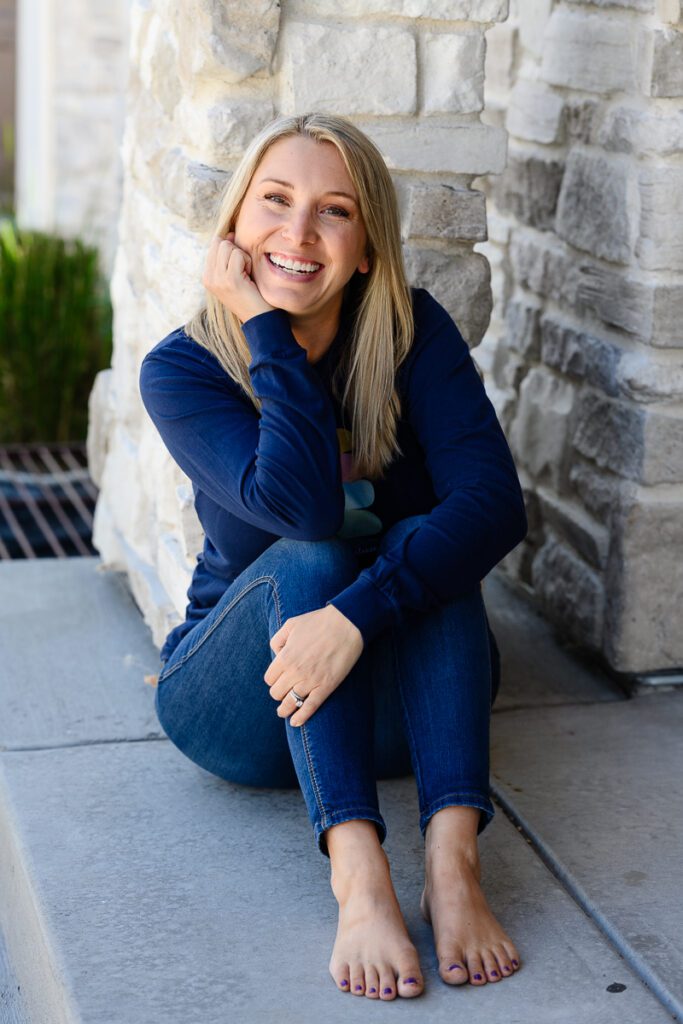 A blonde small business owner sitting smiling at a Denver branding photographer and brand strategist.