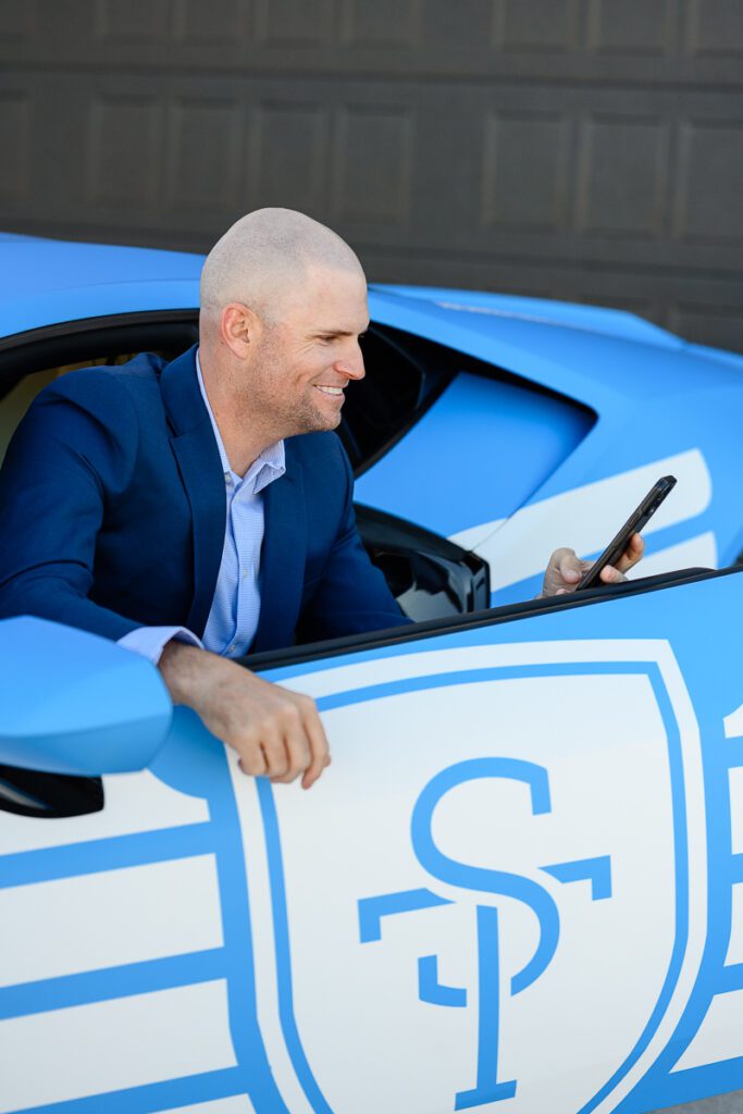 A man with sitting in a blue Lamborghini as captured by a Denver branding photographer and brand consultant.