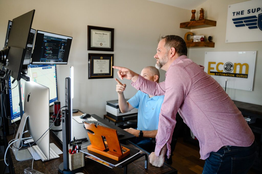 Two business men pointing at computer screens for their Denver Branding photos captured by Denver Commercial photographers and branding strategist.