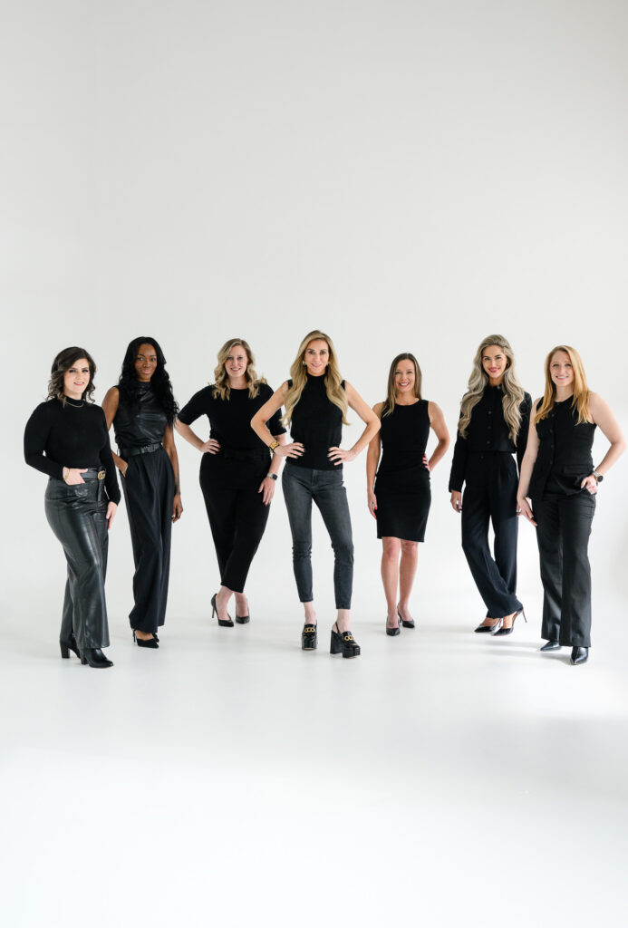 Team of business professionals standing together in coordinated black attire during a branding photoshoot, showcasing leadership, collaboration, and a unified company culture captured by Denver commercial photographers.